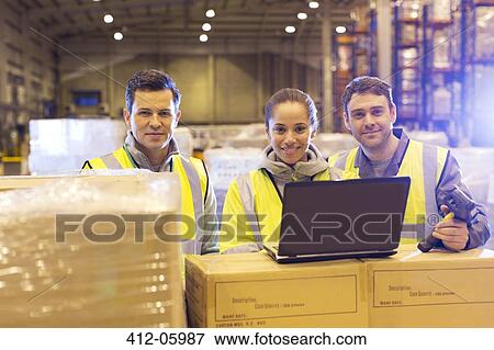 Workers using laptop in warehouse View Large Photo Image Stock Photo - Workers using laptop in warehouse. Fotosearch