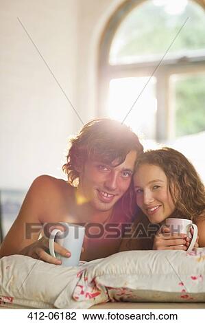 Couple having coffee together in bed View Large Photo Image Stock Image - Couple having coffee together in bed. Fotosearch