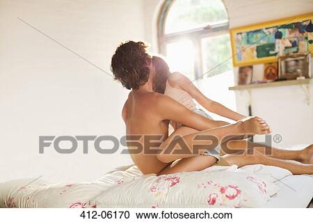 Stock Image - Couple hugging on bed. Fotosearch
