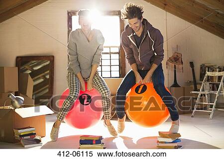 Stock Photography - Couple jumping on exercise balls together. Fotosearch