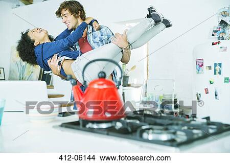 Couple playing together in kitchen View Large Photo Image Picture - Couple playing together in kitchen. Fotosearch