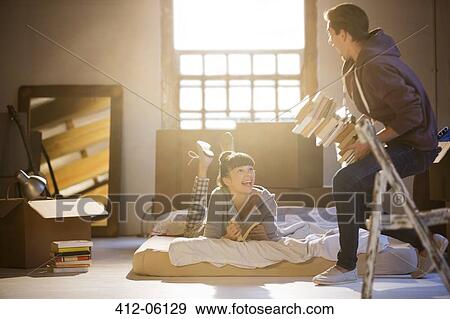 Couple relaxing in attic View Large Photo Image Stock Photo - Couple relaxing in attic. Fotosearch