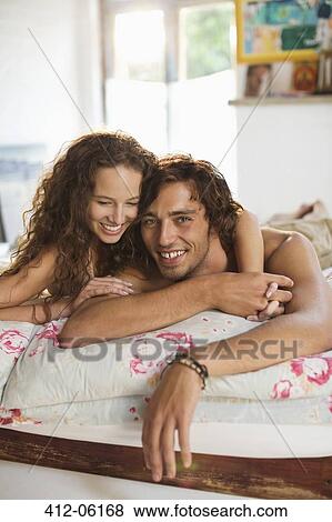 Couple relaxing together in bed View Large Photo Image Stock Photo - Couple relaxing together in bed. Fotosearch
