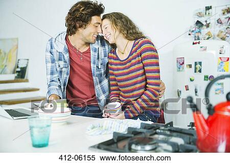Couple relaxing together in kitchen View Large Photo Image Stock Photography - Couple relaxing together in kitchen. Fotosearch