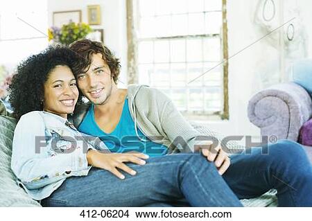 Couple relaxing together on sofa View Large Photo Image Picture - Couple relaxing together on sofa. Fotosearch