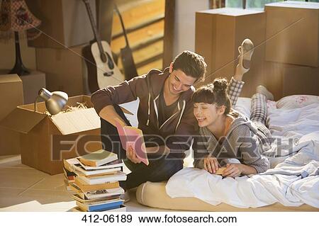Couple unpacking books in new home View Large Photo Image Stock Photo - Couple unpacking books in new home. Fotosearch