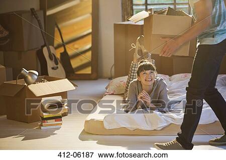 Stock Photo - Couple unpacking boxes in attic. Fotosearch