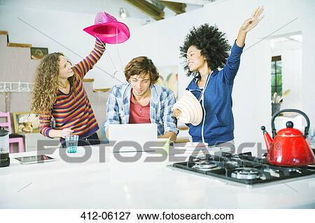 Friends playing in kitchen View Large Photo Image Stock Photo - Friends playing in kitchen. Fotosearch