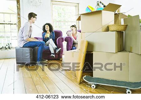 Friends relaxing in new home View Large Photo Image Stock Image - Friends relaxing in new home. Fotosearch