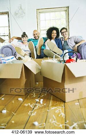 Friends relaxing in new home View Large Photo Image Stock Photo - Friends relaxing in new home. Fotosearch