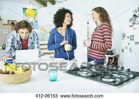 Friends relaxing together in kitchen View Large Photo Image Stock Image - Friends relaxing together in kitchen. Fotosearch
