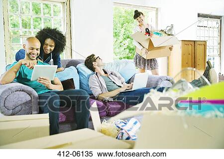 Stock Photography - Friends relaxing together in new home. Fotosearch