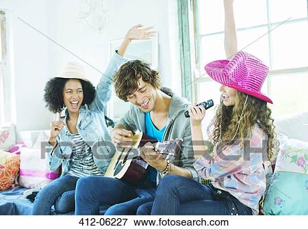Stock Photo - Friends singing and playing music together. Fotosearch
