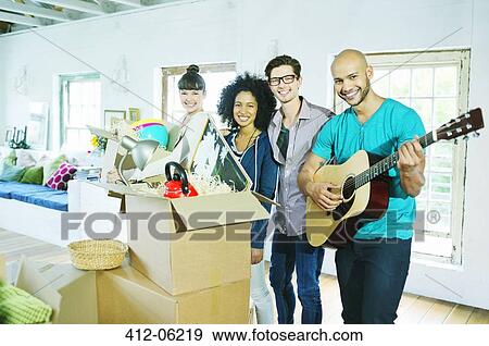 Friends smiling in new home View Large Photo Image Stock Photo - Friends smiling in new home. Fotosearch