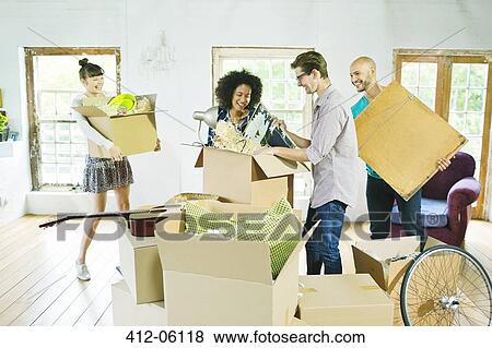 Friends unpacking boxes in new home View Large Photo Image Stock Photo - Friends unpacking boxes in new home. Fotosearch