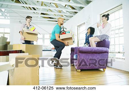 Friends unpacking boxes in new home View Large Photo Image Stock Photography - Friends unpacking boxes in new home. Fotosearch