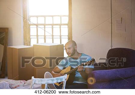 Man playing guitar in new home View Large Photo Image Stock Image - Man playing guitar in new home. Fotosearch