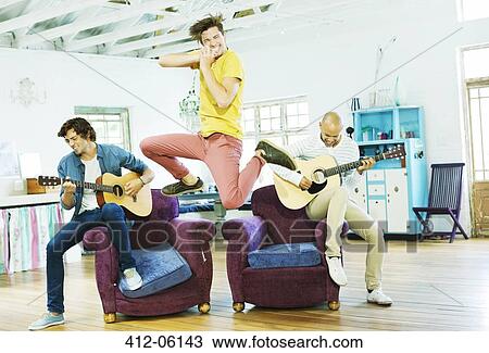 Men playing music together in living room View Large Photo Image Stock Image - Men playing music together in living room. Fotosearch