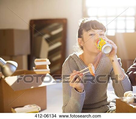 Woman drinking soda and eating sushi in new home View Large Photo Image Picture - Woman drinking soda and eating sushi in new home. Fotosearch