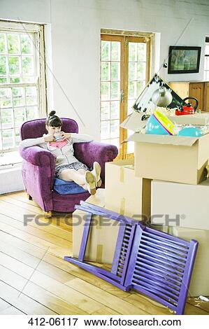 Woman drinking tea with unpacked boxes View Large Photo Image Stock Photo - Woman drinking tea with unpacked boxes. Fotosearch