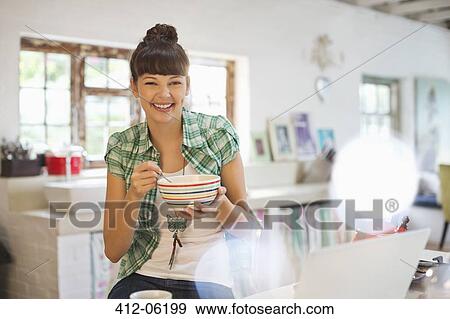 Woman eating in kitchen View Large Photo Image Stock Photo - Woman eating in kitchen. Fotosearch