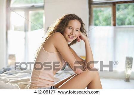 Stock Photo - Woman smiling on bed. Fotosearch