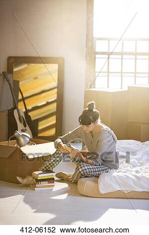 Woman unpacking box in new home View Large Photo Image Stock Image - Woman unpacking box in new home. Fotosearch