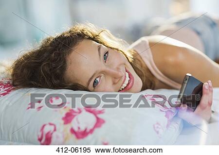 Woman using cell phone in bed View Large Photo Image Stock Photography - Woman using cell phone in bed. Fotosearch
