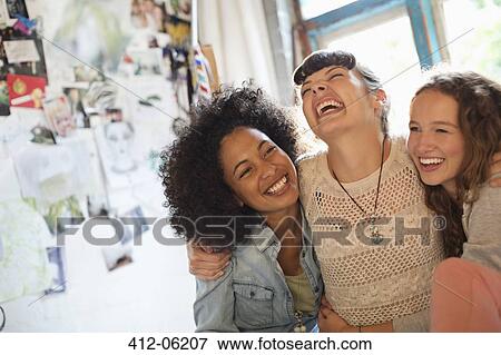 Stock Photo - Women laughing together indoors. Fotosearch