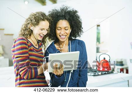 Women listening to earphones together View Large Photo Image Stock Photo - Women listening to earphones together. Fotosearch