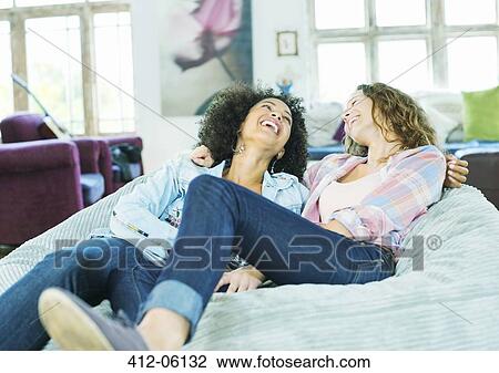 Women relaxing in beanbag chair together View Large Photo Image Stock Image - Women relaxing in beanbag chair together. Fotosearch