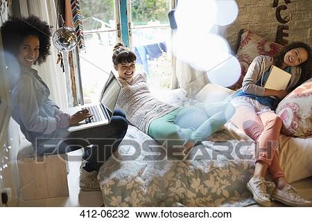 Women relaxing together in bedroom View Large Photo Image Stock Image - Women relaxing together in bedroom. Fotosearch