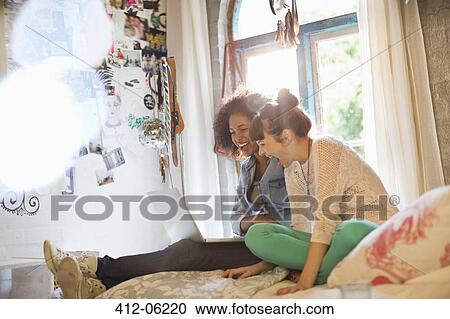 Women using laptop together in bedroom View Large Photo Image Stock Image - Women using laptop together in bedroom. Fotosearch