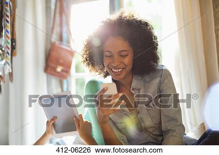 Women using tablet computer and cell phone in bedroom View Large Photo Image Stock Photograph - Women using tablet computer and cell phone in bedroom. Fotosearch