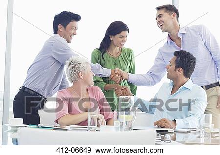 Stock Photo - Business people shaking hands in meeting. Fotosearch