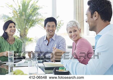 Business people smiling in lunch meeting View Large Photo Image Stock Photo - Business people smiling in lunch meeting. Fotosearch