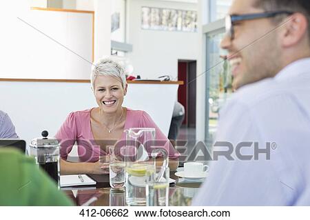 Business people smiling in meeting View Large Photo Image Stock Image - Business people smiling in meeting. Fotosearch