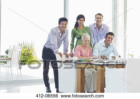 Business people smiling together in office View Large Photo Image Stock Photograph - Business people smiling together in office. Fotosearch
