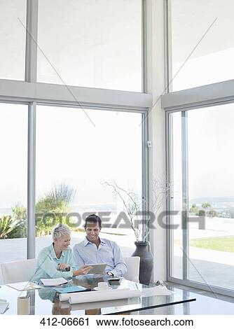 Stock Image - Business people talking on sofa in office. Fotosearch