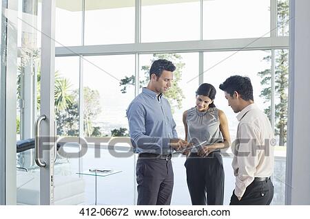 Stock Image - Business people using tablet computer in office. Fotosearch