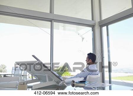 Businessman looking out office window View Large Photo Image Picture - Businessman looking out office window. Fotosearch