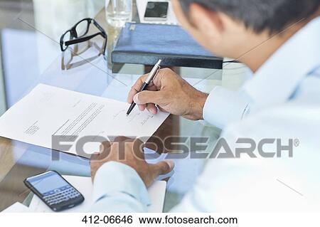 Businessman making notes at desk View Large Photo Image Stock Photograph - Businessman making notes at desk. Fotosearch