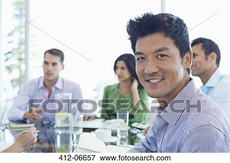 Businessman smiling in meeting View Large Photo Image Stock Photo - Businessman smiling in meeting. Fotosearch