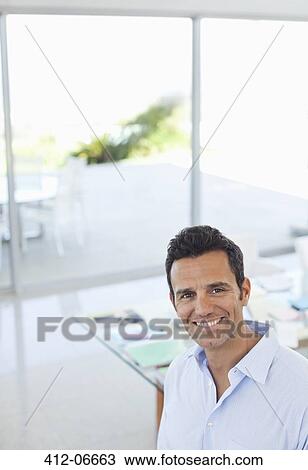 Businessman smiling in office View Large Photo Image Stock Image - Businessman smiling in office. Fotosearch