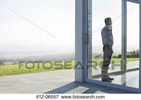 Stock Photo - Businessman standing at office window. Fotosearch