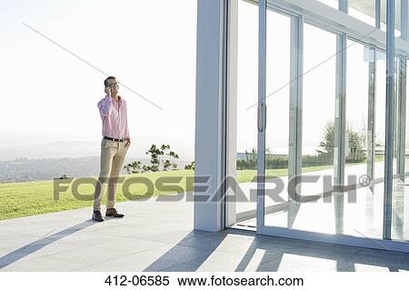 Stock Photography - Businessman talking on cell phone outdoors. Fotosearch