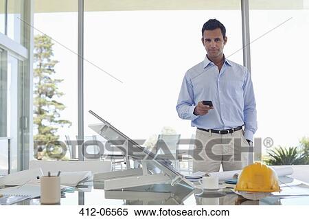 Stock Photography - Businessman using cell phone in office. Fotosearch