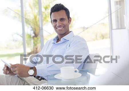 Stock Image - Businessman using tablet computer at desk. Fotosearch