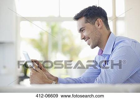 Businessman using tablet computer at desk View Large Photo Image Stock Photo - Businessman using tablet computer at desk. Fotosearch