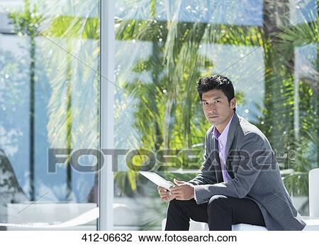 Stock Image - Businessman using tablet computer in office. Fotosearch